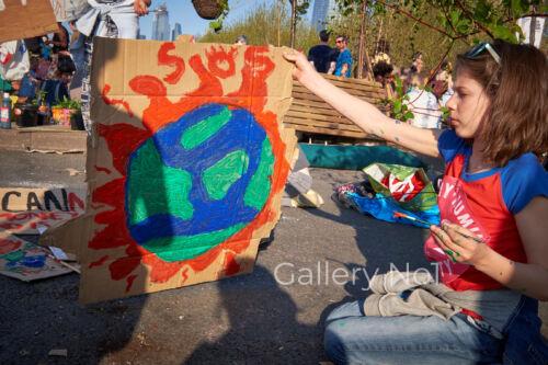 FIND PHOTOGRAPH OF GIRL PAINTING WORL PLACARD AT EXTINCTION REBELLION PROTEST IN LONDON